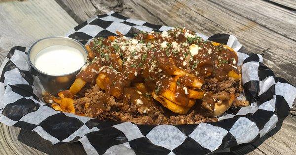 Pot Roast Sandwich - HOT BEEF! A mound of pot roast served on a French roll topped with curly fries, rich brown  gravy, and cotija cheese.