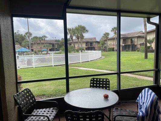 Screened in patio with pool view.