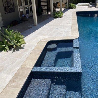 Laguna Beach, CA pool remodel with new Bahamas Jewel Pebble finish, new tile and travertine coping.