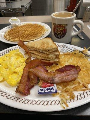 Waffle, hash browns, bacon, scrambled eggs, toast, and coffee.