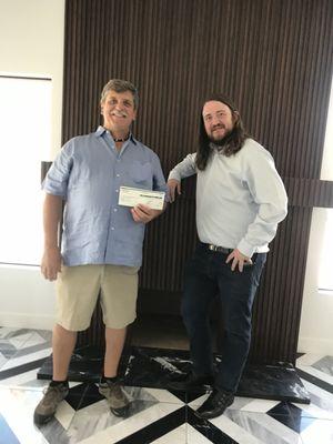 Attorney Zachary Clayton delivers justice with a settlement check to a client after a successful car accident case.