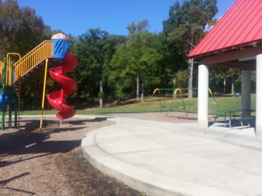 Very tall swirly slide plus baby swings and kid swings.