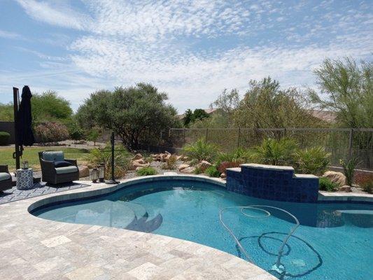 Pool remodel with new water feature, waterline tile and coping to match the travertine patio