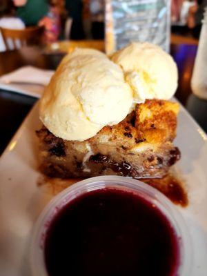 Bacon chocolate chip bread pudding with a side of blueberry sauce.