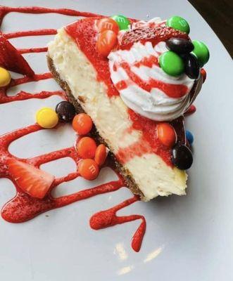 Housemade Vanilla Cheesecake with fresh strawberry sauce, strawberries, whipped cream, and m&m's!