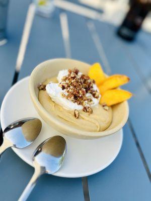 Bourbon pudding with whipped cream and fresh peaches