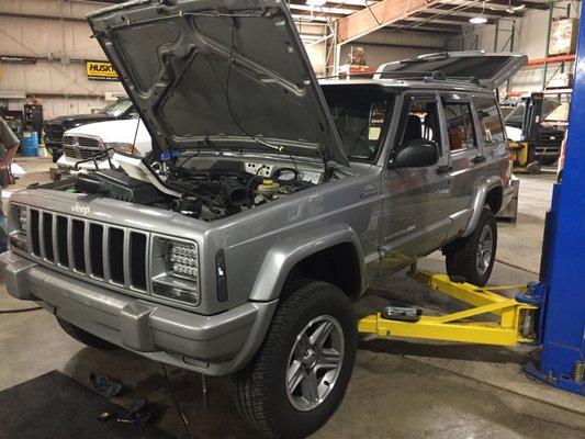 Jeep Cherokee on the lift about to get a lift kit installed at CPW Truck Stuff