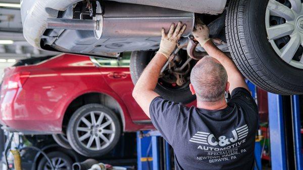 Our lead technician Nick working on replacing a muffler.