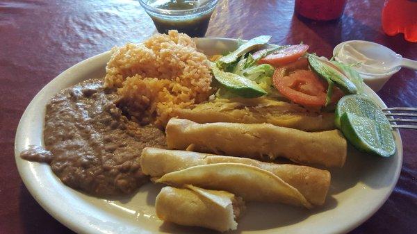 Flautas de pollo, with rice and beans garnished with shredded lettuce, sliced tomatoe, and sliced avacado.