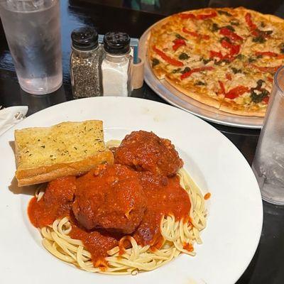 Meatballs with pasta and chicken pesto pizza in the back