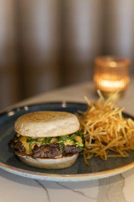 SMASHED BURGER with american cheese . lettuce . caramelized onions . pickles . housemade english muffin . french fries