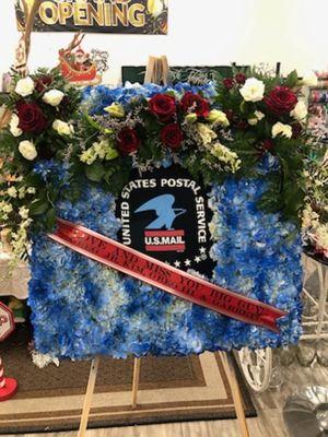 This memorial arrangement was designed to honor a 50 year Veteran of the USPS.