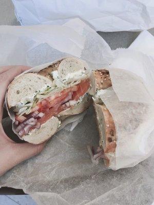 Everything bagel with salmon lox, scallion cream cheese, lettuce, tomato, and onions