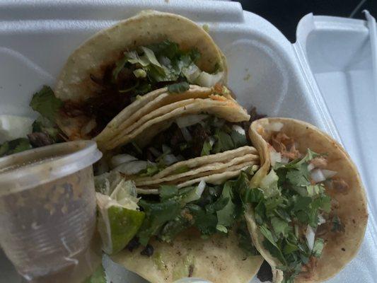 2 carne asada tacos, 1 shredded beef taco, and 1 spicy pork taco. With some tomatillo salsa, guacamole salsa, radish, and lime.