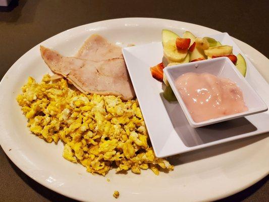 Scrambled eggs with turkey ham and fruit with yogurt.