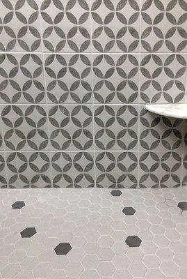 Shower accent wall and hex tile shower floor with random darker sample tile, marble shelf