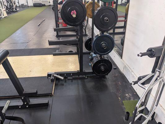 Deadlift/squat area with safety bars with nice cutout for 2.5 lb weights, plus a pivot for pivot presses and the like