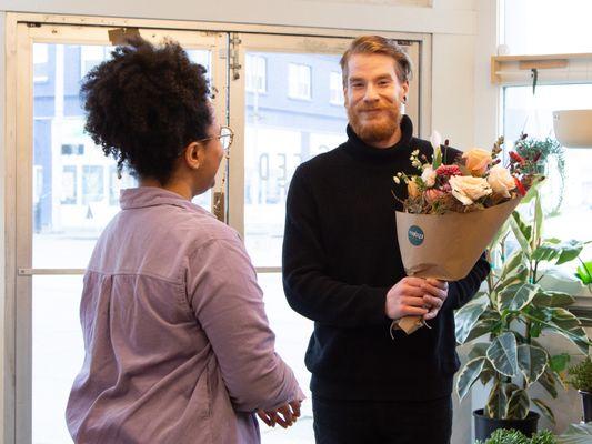 Mikaela helping a shopper at Fernseed with a grab-and-go bouquet