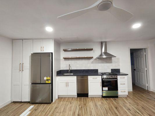 Left side pantry next to fridge is a small laundry room/closet containing a stackable washer/dryer.