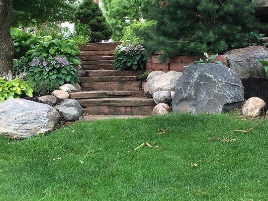 Natural stone stairs flanked with boulders and plants