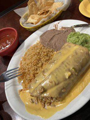 Chimichanga with fajita chicken, queso, rice , beans , guacamole