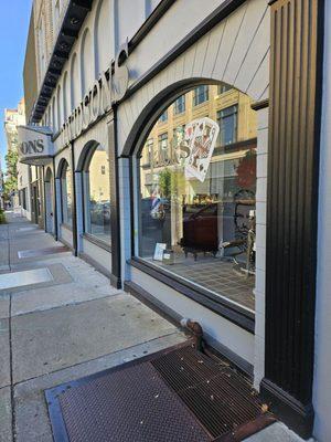 The sidewalk view of the building architectural design of the fine men's clothing store.