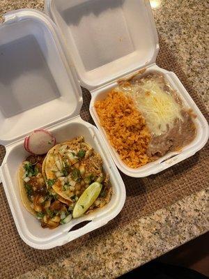 Al pastor and carnitas taco with side of rice and beans