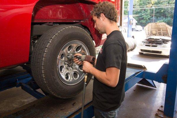 Mechanic at Faulkenburg Automotive removing a tire.