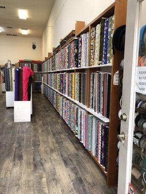 A long wall of colorful quality cotton fabrics for quilting and garments.