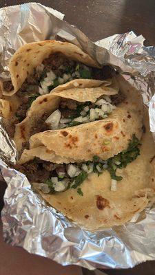 Tacos with beef fajita, cilantro, and onion