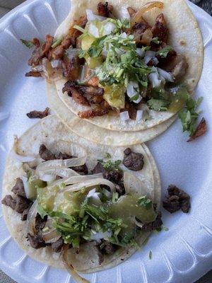 Carne Asada and Al pastor tacos with grilled onions and condiments