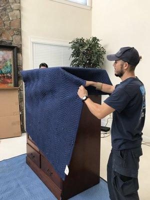 Wrapping dresser with moving blankets and shrinkwrap