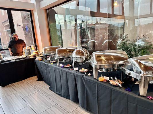 Carving station on the left at Thanksgiving day buffet 2023