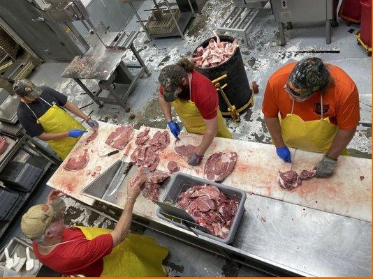 Jerry observing and guiding the guys as they bone out some meat.