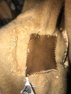 Coat shrunk. The leather tag shriveled so much it tore from the seams. Embossed writing illegible and shriveled.