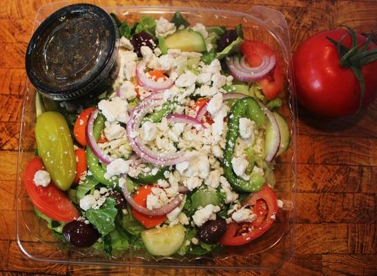 Greek Salad: Lettuce, Tomato,Cucumbers, Carrots, Green Pepper, Pepperoncini, Greek Olives, Feta Cheese & Homemade Greek Dressing.