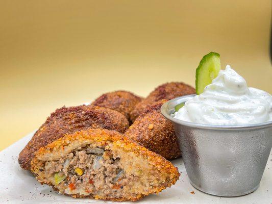 Kibbeh, a crushed wheat football filled & fried with a slightly spicy ground beef & vegetables mix made in house