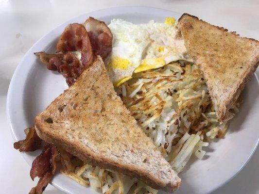 2 eggs fried hard, whole wheat toast, bacon and hash browns with onions