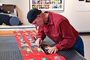 Hand cutting a 9 foot long fanfold book.