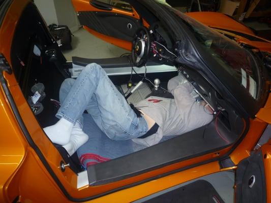 under the dash of a Lotus Exige.  There's really cramped wven with the seat removed.