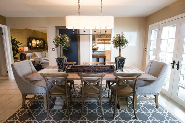 Dining room with reclaimed table and cozy end chairs. Beautiful lighting and accessories