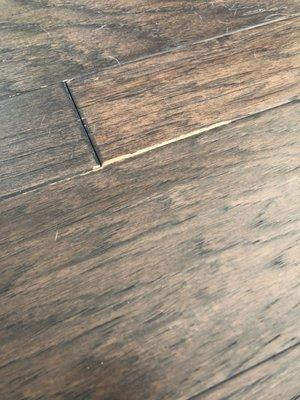 Engineered hardwood floor and stain comes off easily to show bare wood below