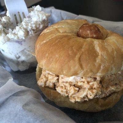 Buffalo chicken salad croissant with a side of potato salad.