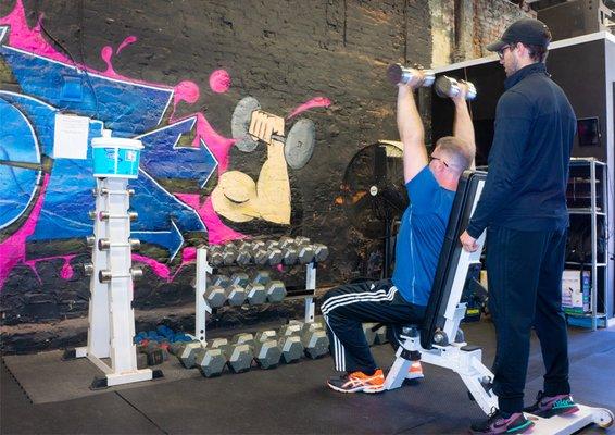 Owner/Trainer John spotting his personal training client