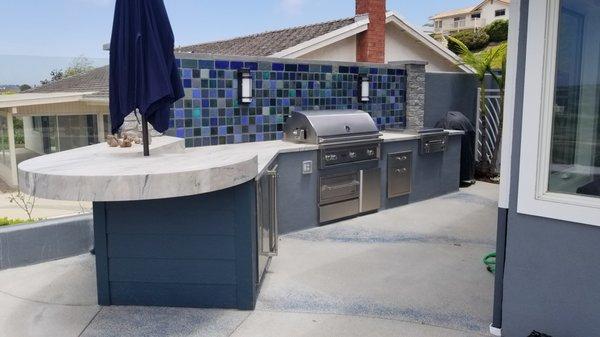 BBQ with Quartzite countertop. Handmade custom tile screen wall & lights. Blue glass pebble concrete insets.