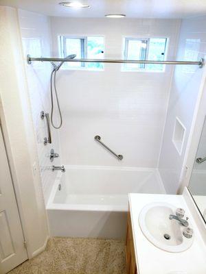 Simple, but beautiful all white bathtub remodel with chrome fixtures.