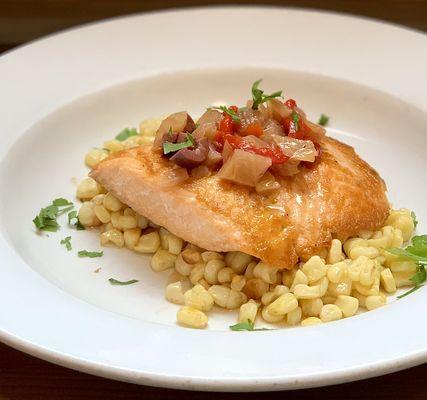 Fresh king salmon over sweet corn and topped with bell pepper, olives and capers