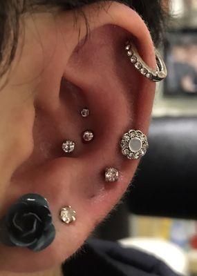 Triple conch piercing done with flat back diamonds.