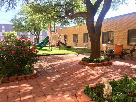 Outdoor garden, seating area, and playground for visiting children.