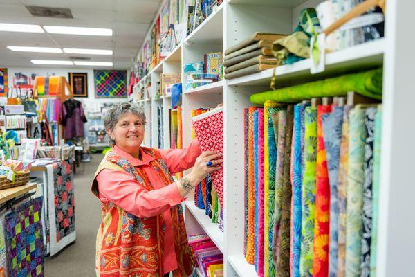 Judy Gula, owner Artistic Artifacts, with a selection of the Batik Tambal batik fabrics exclusive to the shop.